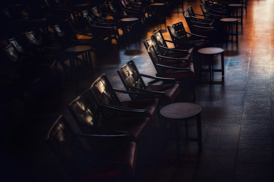 Rows of empty theatre seats in dim ambient light
