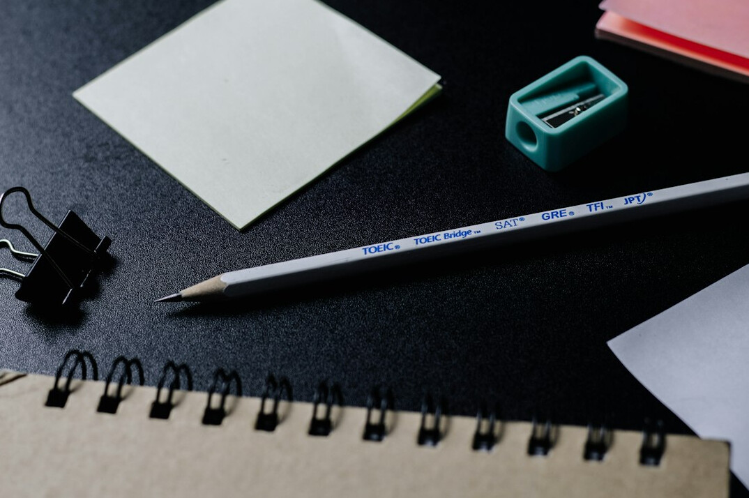 Handwritten research notes and archival documents spread across a wooden desk